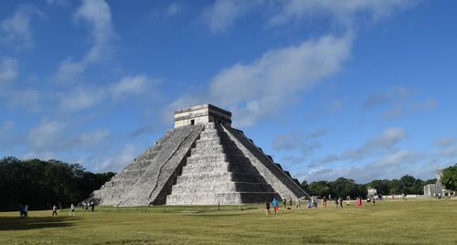 Group of people in front of historical building against sky