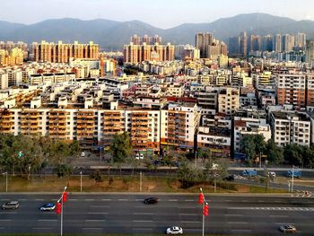 Vehicles on road by buildings in city