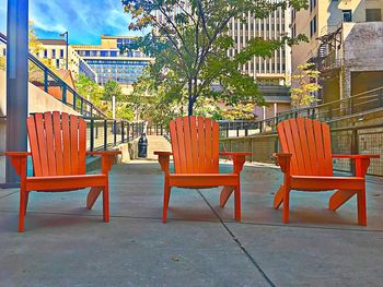 Empty chairs and tables against building