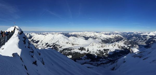 Scenic view of snowcapped mountains against blue sky