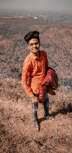 Full length portrait of boy standing against landscape