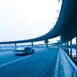 Bridge over highway against clear sky