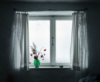 Flower vase at window in bedroom
