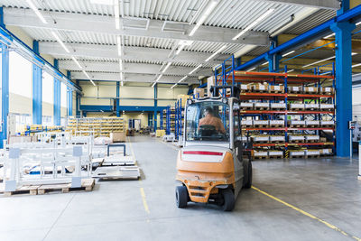 Man on forklift in factory warehouse