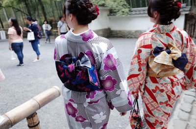 Rear view of women wearing kimono standing on street