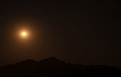 Scenic view of silhouette mountains against sky at night