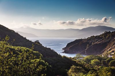 Scenic view of sea and mountains against sky