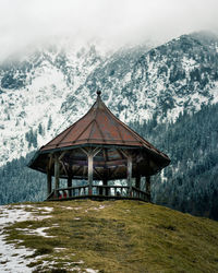 Built structure on snowcapped mountain against sky