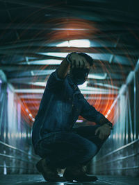 Side view of young man holding camera at night