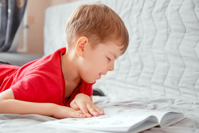 Cute boy lying on bed at home