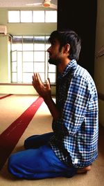 Side view of man sitting at home