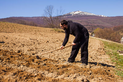 Full length of man standing on field against sky