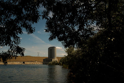 Silhouette trees by lake against sky during sunset