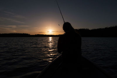 Rear view of man standing by lake