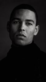 Close-up portrait of young man against gray background