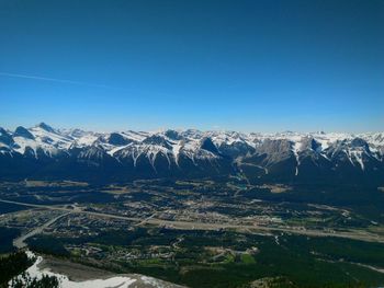 Aerial view of mountain range against blue sky