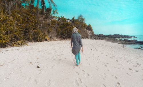 Rear view of man walking on beach