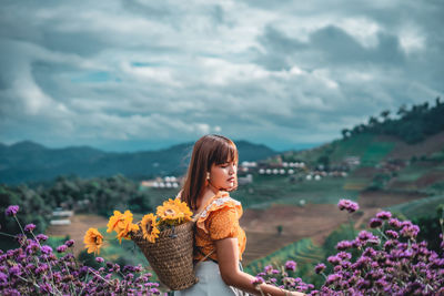 Woman standing on purple flowering plant