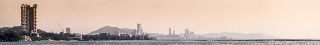 Panoramic view of buildings by river against sky