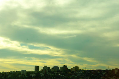 Cityscape against cloudy sky