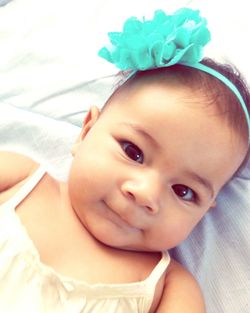 Portrait of cute baby lying on bed