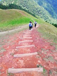 Rear view of people walking on footpath