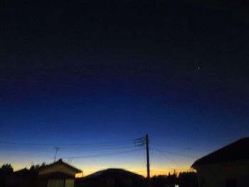 Silhouette of electricity pylon against sky at sunset