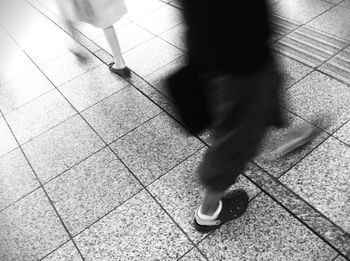 Low section of people standing on tiled floor