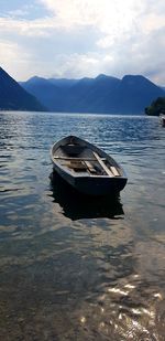 Boat moored in lake against sky