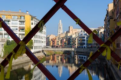 Reflection of buildings in city against clear sky