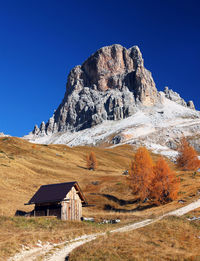 Scenic view of house and mountains against clear blue sky