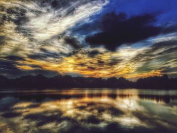 Scenic view of calm lake against cloudy sky