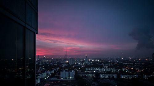 Illuminated cityscape against sky at night