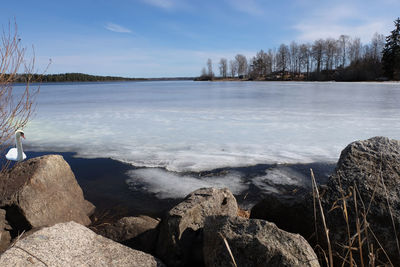 View over frozen lake with rocks in foreground