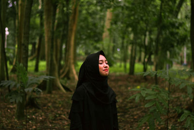 Woman standing in forest