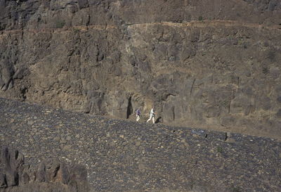 People walking against cliff