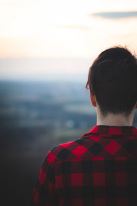 Man dressed in red checked shirt looking into his future. authentic mood of young man on journey