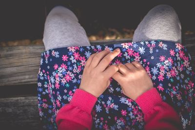 Midsection of girl sitting on bench