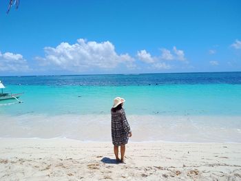 Full length of woman standing on beach against sky