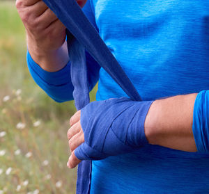 Close-up of man wrapping bandage