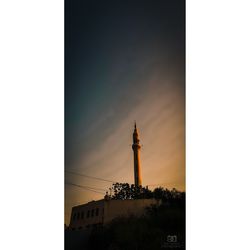 Low angle view of silhouette building against sky at sunset