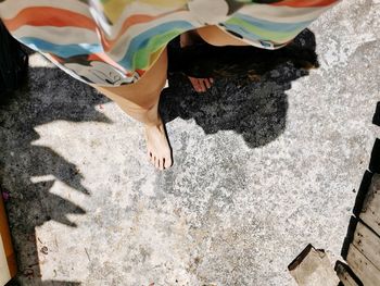 Low section of woman standing on sand