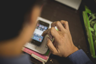 Cropped image of businessman using mobile phone at desk in office
