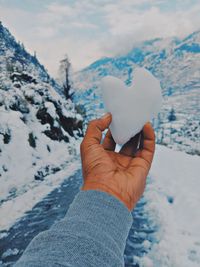 Cropped hand of woman holding snow