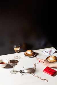 Still life of clutch purse, woman's hand and after dinner deserts