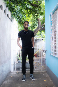 Portrait of young man standing against wall