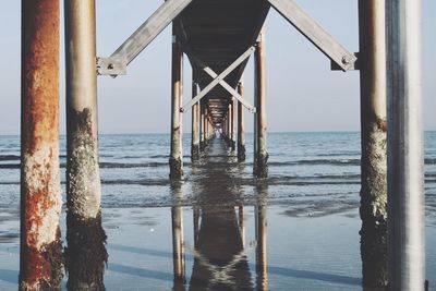 Pier on sea against clear sky during sunset