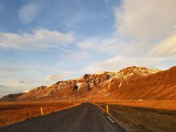 Road by mountain against sky