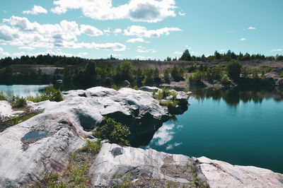 Scenic view of lake in forest against sky