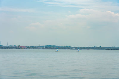 Sailboats in sea against sky
